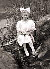 Girl sitting beside a stream